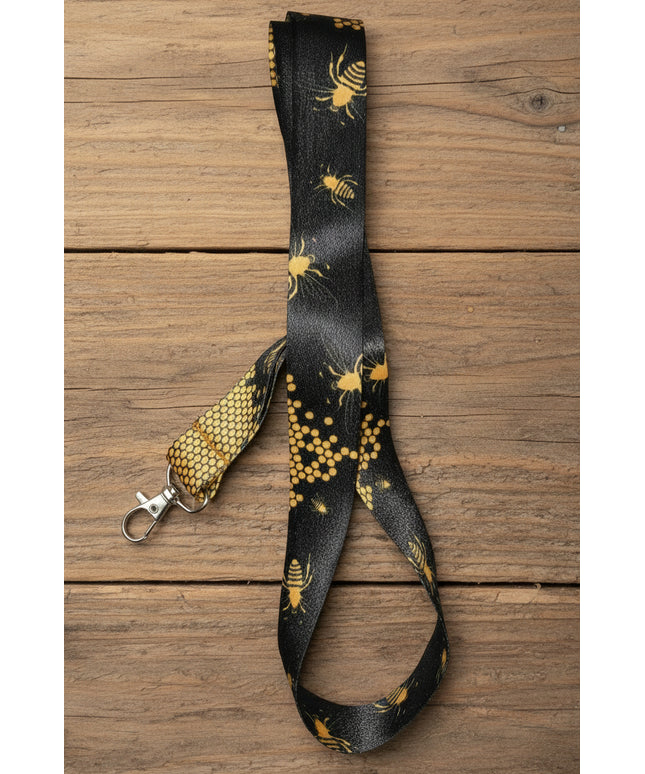 Black lanyard with yellowish gold bees and honeycomb pattern