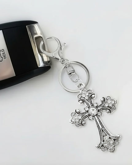 Silver gothic cross keychain and charm with colorless rhinestones attached to a key fob