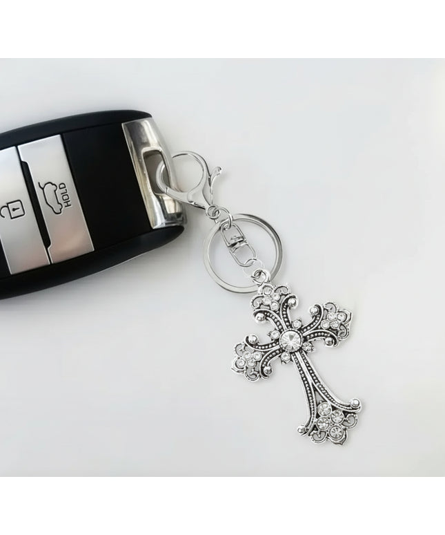 Silver gothic cross keychain and charm with colorless rhinestones attached to a key fob