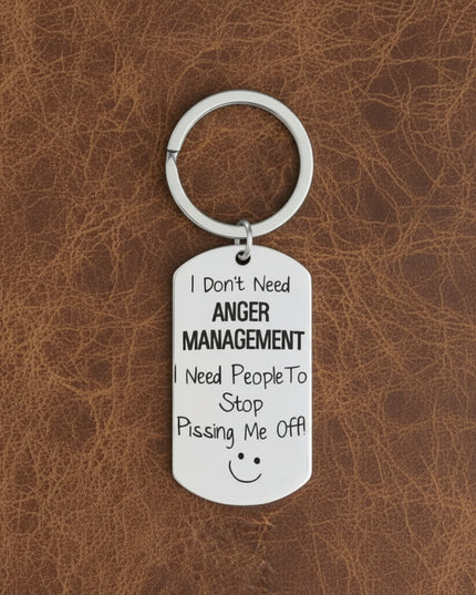 Keychain with humorous text on a gray surface with plants