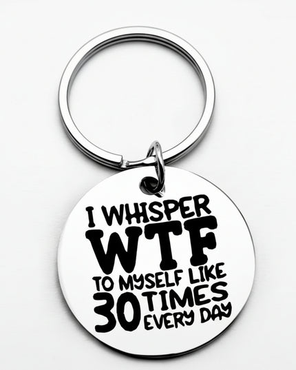 Keychain with humorous text 'I whisper WTF to myself like 30 times every day' on a white background