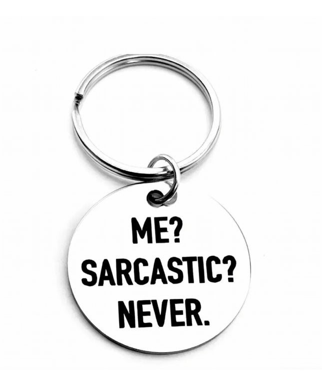 Silver keychain with round charm etched with words Me? Sarcastic? Never. in black font