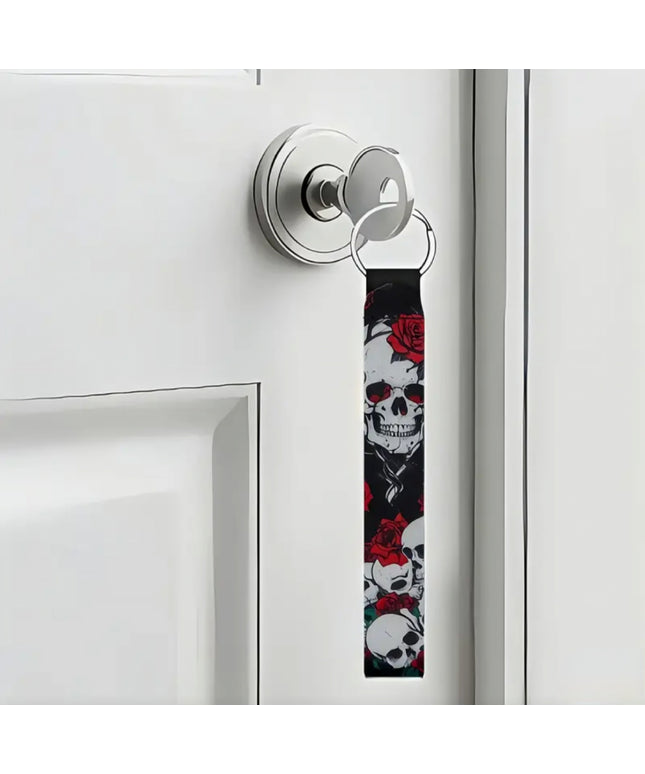 Keychain with skull design attached to a door handle.