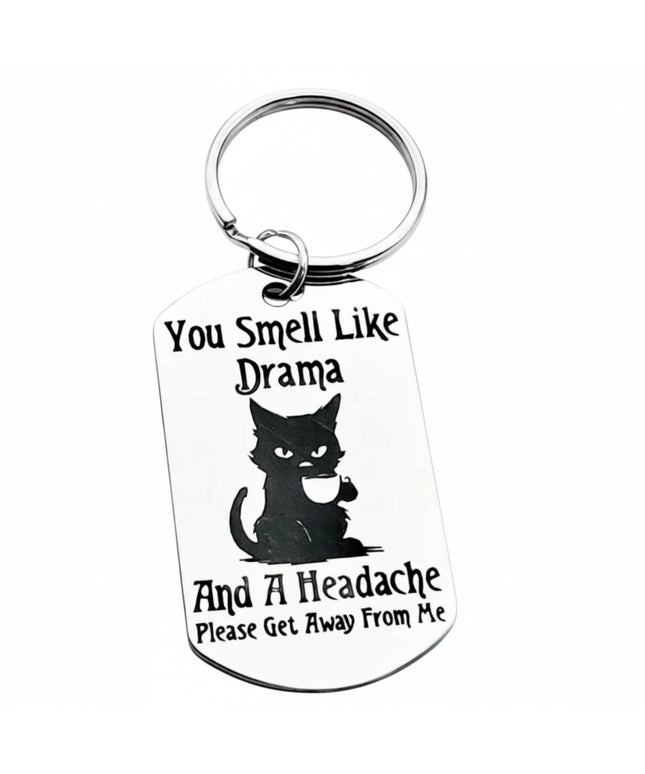 Keychain with a black cat illustration and humorous text on a white background