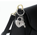 Heart-shaped keychain with lock design attached to a black bag.