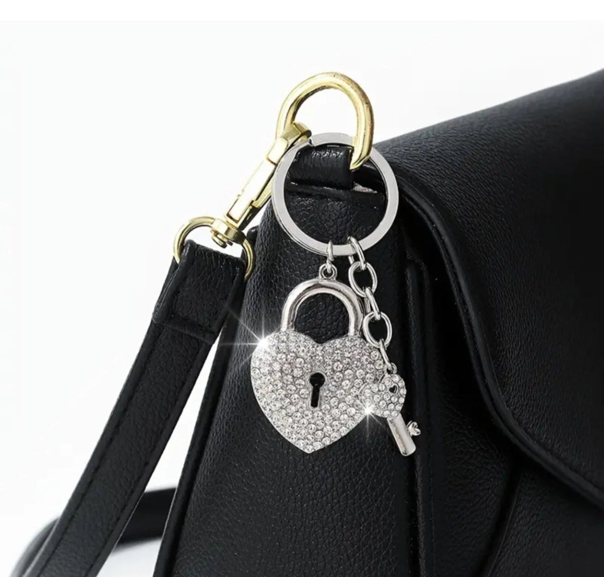 Heart-shaped keychain with lock design attached to a black bag.